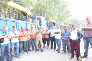 Les conducteurs de nouveaux engins posant fièrement devant leurs camions flambant neuf